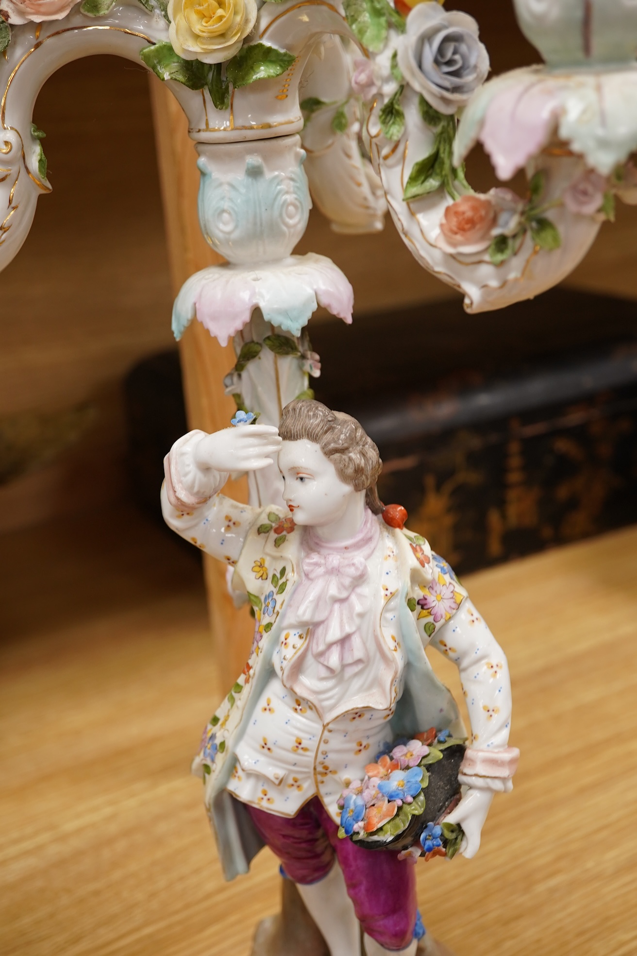 A pair of Volkstedt porcelain figural three branch candelabra with floral encrusted decoration, 51cm high